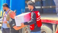  QRCS staff distribute food items to the needy during one of their international outreaches recently.