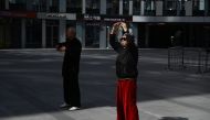 A man and woman perform martial arts exercises at a shopping mall in Beijing on March 17, 2024. (Photo by GREG BAKER / AFP)