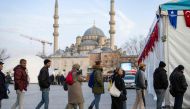 Worshippers queue to receive meals for iftar from local authorities during of the holy month of Ramadan at the Eminonu Square in Istanbul on March 15, 2024. Photo Credit: Yasin AKGUL / AFP.