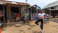 (FILES) A student of the Leap of Dance Academy, Anthony Madu (R), performs a ballet dance routine in front of his mother's shop in Okelola street in Ajangbadi, Lagos, on July 3, 2020. (Photo by Benson Ibeabuchi / AFP)
