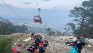 This handout photograph taken and released on April 12, 2024 by Turkish news agency DHA (Demiroren News Agency) shows rescue teams conducting a rescue operation and helping injured people after a cable car cabin crashed into a fallen cable pole in Konyaalti district of Antalya. (Photo by Handout / DHA (Demiroren News Agency) / AFP)