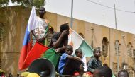 Young boys gather on top of a car while displaying flags of Niger, Burkina Faso and Russia during a demonstration for the immediate departure of United States Army soldiers deployed in northern Niger in Niamey, on April 13, 2024. (Photo by AFP)
