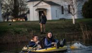 People travel in a boat in floodwater from the overflowing Nerl River in front of the Church of the Intercession on the Nerl off the settlement of Bogolyubovo in the Vladimir region on April 13, 2024. Photo by Valery MELNIKOV / AFP.