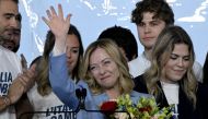 Italy's Prime Minister, Giorgia Meloni stands on stage surrounded by young people after her speech during the campaign meeting of the far-right party Fratelli d'Italia (Brothers of Italy) ahead of the European Elections, on April 28, 2024 in Pescara. (Photo by Tiziana FABI / AFP)
