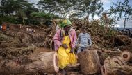  A woman walks in an area full of damaged trees, mud and debris carried by water following flash floods and landslides in Mai Mahiu, on April 30, 2024. Photo by LUIS TATO / AFP