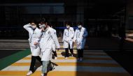 Medical workers walk across a pedestrian crossing outside a hospital in Seoul on March 11, 2024. Photo by Anthony WALLACE / AFP