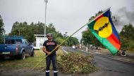 The resident in charge of the independantist roadblock at La Tamoa, holds a Kanak flag in the commune of Paita, France's Pacific territory of New Caledonia on May 19, 2024. Photo by Delphine Mayeur / AFP.