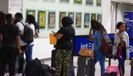 People wait in line for a flight at Toussaint Louverture Airport in Port-au-Prince on May 20, 2024. (Photo by Clarens Siffroy / AFP)

