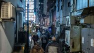 This picture taken on March 22, 2024 shows tourists from the US walking down a small alleyway as they take part in a snack bar tour in Tokyo. Photo by Yuichi YAMAZAKI / AFP
