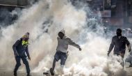 A protester kicks a tear gas canister while demonstrating during a nationwide strike to protest against tax hikes and the Finance Bill 2024 in downtown Nairobi, on June 25, 2024. (Photo by Luis Tato / AFP)