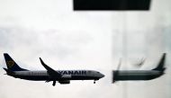 File photo of a Ryanair Boeing 737-8AS aircraft is reflected in a window as it prepares to land at London Gatwick Airport, near Crawley, southern England, on September 26, 2023. (Photo by Ben Stansall / AFP)
