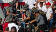 A person is removed by state police from the stands after guns were fired at Republican candidate Donald Trump at a campaign event at Butler Farm Show Inc. in Butler, Pennsylvania, July 13, 2024. (Photo by Rebecca Droke / AFP)