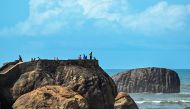 Tourists climb a rock at Galle Fort in Galle on July 15, 2024. (Photo by Ishara S. KODIKARA / AFP)
