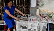 A vendor arranges newspapers reporting on the death of Nguyen Phu Trong, the general secretary of the Communist Party of Vietnam, in Hanoi on July 20, 2024. (Photo by Nhac Nguyen / AFP)