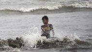 A boy cools off in the Arabian Sea during a hot summer day in Karachi on July 18, 2024. (Photo by Rizwan Tabassum / AFP)
