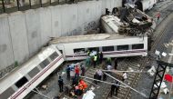 Rescuers tend to victims next to derailed cars at the site of a train accident near the city of Santiago de Compostela on July 24, 2013. Photo by Oscar CORRAL / AFP