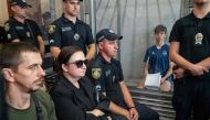 Vyacheslav Zinchenko, 18, suspected of killing Iryna Farion, a prominent former nationalist lawmaker and professor at the Lviv's Institute of the Humanities and Social Sciences, stands in a prisoner's box as he attends his hearing at the Lviv court in Lviv, on July 26, 2024. (Photo by Ivan STANISLAVSKY / AFP)
