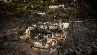 This photograph shows a view of a burnt houses following a wildfire that hit the north-eastern suburbs of athens, near Penteli, suburb of athens, on August 13, 2024. On August 13, 2024, Greece continued for the third consecutive day to fight a fire in the north-eastern suburbs of athens, which has killed one person, forced thousands from their homes and polluted the air in the capital. (Photo by Angelos TZORTZINIS / AFP)
