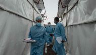 Health workers walk between wards at the Mpox treatment centre at Nyiragongo General Referral Hospital, north of Goma on August 17, 2024. (Photo by GUERCHOM NDEBO / AFP)
