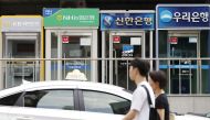 Automated teller machines of local commercial banks are lined up on a street in Seoul, S Korea.