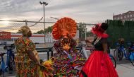 Three people take a break during the annual street party J'ouvert on September 2, 2024 in New York City. (Photo by Adam Gray / GETTY IMAGES NORTH AMERICA / Getty Images via AFP)
