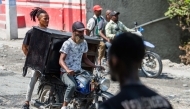 People flee their neighborhood after armed gangs terrorized the Delmas 24 and Solino areas, in Port-au-Prince, Haiti, October 20, 2024. (Photo by Clarens SIFFROY / AFP)
