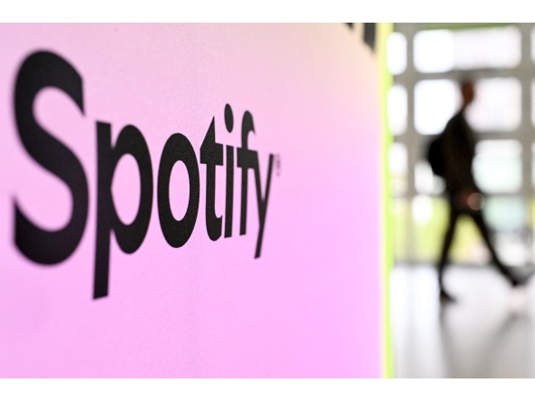 A person walks past a banner with an Spotify logo at the Frankfurt book fair on October 17, 2024. Photo by Kirill KUDRYAVTSEV / AFP