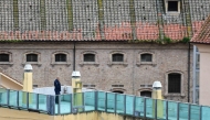 (Files) A prison guard patrols a prison building's terrace overlooking the prison's wings, after smoke billowed from a rooftop of the Regina Coeli prison in central Rome on March 9, 2020. (Photo by Alberto Pizzoli / AFP)