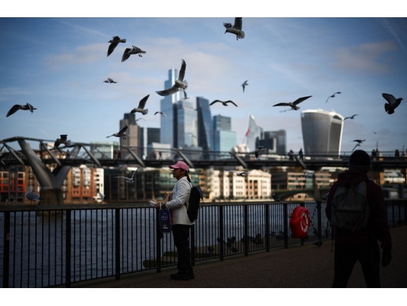 File photo: Seagulls fly over people walking on the Southbank of the River Thames backdropped by the business and financial district in central London on November 15, 2024. Photo by HENRY NICHOLLS / AFP.