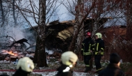 Lithuanian rescuers work next to the wreckage of a cargo plane following its crash near the Vilnius International Airport in Vilnius on November 25, 2024. A cargo plane flying from Germany to Lithuania crashed early on November 25, 2024 near the airport of the capital Vilnius killing one person, firefighters said. Photo by Petras MALUKAS / AFP.

