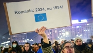 People protest in the front of the Palace of the Parliament at the Victory square in Bucharest, Romania, on November 27, 2024, with a banner reading 