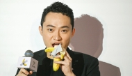 Chinese-born crypto founder Justin Sun eats banana artwork, in Hong Kong on November 29, 2024. (Photo by Peter Parks / AFP)
