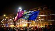 Demonstrators hold EU and Romanian national flags during a pro-European rally and in support of democracy at Piata Universitatii square in Bucharest on December 5, 2024. (Photo by Daniel Mihailescu / AFP)