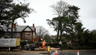 Arborists cut a tree blocking a road in Birkenhead, near Liverpool, on December 7, 2024 as storm Darragh brings winds of nearly 90 mph to the west of Wales and north-west England. (Photo by Paul Ellis / AFP)
