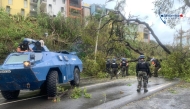 This handout photograph released by the Gendarmerie nationale on December 15, 2024 and taken on that day at an undisclosed location on the French Indian Ocean territory of Mayotte shows French gendarmes near their armored vehicle Berliet VXB-170 (or VBRG) as they work to remove an unrooted tree from a road, a day after the cyclone Chido hit the archipelago. Photo by Handout / GENDARMERIE NATIONALE / AFP.