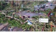 This undated handout photograph taken in the wake of Cyclone Chido and released by the Gendarmerie Nationale on December 17, 2024 shows French Gendarme clearing a fallen tree on a road at an undisclosed location on the French Indian Ocean territory of Mayotte. Photo by Handout / GENDARMERIE NATIONALE / AFP.