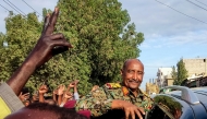 (FILES) People cheer as Sudan's de facto leader, armed forces chief Abdel Fattah al-Burhan arrives at the market in Port Sudan on December 29, 2024. (Photo by AFP)
