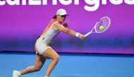 Poland's Iga Swiatek hits a return to Kazakhstan's Elena Rybakina during their quarter-final yesterday. 