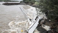 A yacht, swept away by the waves, rests at Point Danger on the southern end of the Gold Coast on March 7, 2025. Photo by David GRAY / AFP