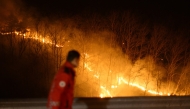 A member of the Korea Forest Service observes a wildfire from the side of a road in Andong early on March 27, 2025. Photo by ANTHONY WALLACE / AFP
