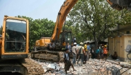Heavy construction equipment is used to dig through the rubble as people look for survivors in a destroyed building in Mandalay on March 29, 2025, a day after an earthquake struck central Myanmar. Rescuers dug through the rubble of collapsed buildings on March 29 in a desperate search for survivors after a huge earthquake hit Myanmar and Thailand, killing more than 1000 people. (Photo by Sai Aung MAIN / AFP)
