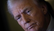 US President Donald Trump listens to a question while speaking to members of the press while returning to Washington, DC on Air Force One on March 30, 2025, in Fredericksburg, Virginia. (Photo by Brendan Smialowski / AFP)