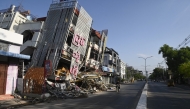 A man on motorcycle rides past a damaged building in Mandalay on April 13, 2025, following the devastating March 28 earthquake. Photo by Sai Aung MAIN / AFP