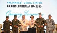 (From left) Philippines Major General Francisco Lorenzo, Philippines exercise director, Philippines military chief General Romeo Brawner, Philippines Secretary of Foreign Affairs US Ambassador to the Philippines Marykay Carlson, US marines Lieutenant General James Glynn, commander of the US marines Pacific and Philippines air force Major general Llewillyn Banaag link arms during the opening ceremony of the annual US-Philippines Balikatan joint military exercise at camp Aguinaldo in Manila on April 21, 2025. (Photo by Ted Aljibe / AFP)