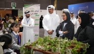 Officials interacting with exhibitors during a tour. 