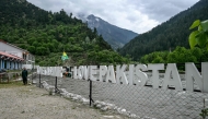A guest house staff stands in an empty tourist place in Keran village on the Line of Control (LoC) in Neelum Valley, a district of Pakistan-administered Kashmir, on May 3, 2025. (Photo by Farooq Naeem / AFP)