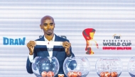 British athlete Mo Farah picks a team during the draw ceremony.