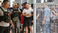 Filipino national Arnolfo Teves (centre), a murder suspect, is escorted by East Timorese security personnel for deportation to his home country at Nicolau Lobato airport in Dili on May 29, 2025. (Photo by Valentino Dariell De Sousa / AFP)
