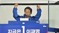 Lee Jae-myung, the presidential candidate for South Korea's Democratic Party, gestures behind bullet-resistant glass at the podium during his final election campaign event ahead of the upcoming June 3 presidential election in Seoul on June 2, 2025. Photo by ANTHONY WALLACE / AFP.
