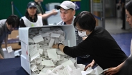 Election officials unload a ballot box at a counting station in Seoul on June 3, 2025. (Photo by Pedro Pardo / AFP)